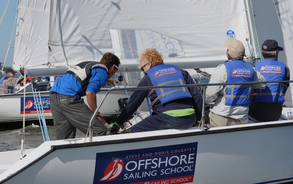 A group of sailors working the sail controls