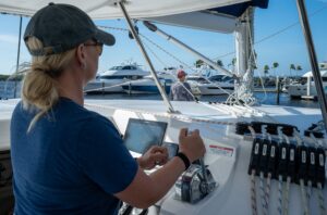 An woman in the Fast Track to Boat Handling & Docking course is learning to dock a large catamaran sailboat