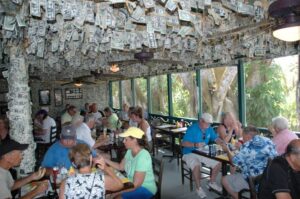People eating at Cabbage Key Restaurant on Pine Island Sound where walls, and ceiling are covered with signed dollar bills