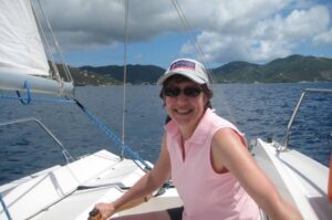 Closeup of a woman steering a Colgate 26 while learning to sail at Offshore Sailing School in BVI
