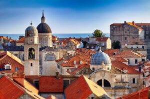 Dubrovnik Old Town with red roofs and two towers of ancient church on left