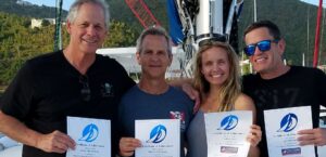 Three guys and a gal showing off their Fast Track to Cruising course catamaran live aboard certificates