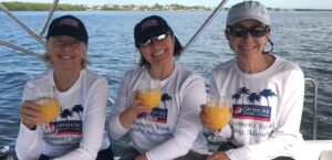 Three women smiling and drinking mimosas after graduation from women-only learn to Sail and cruising courses.